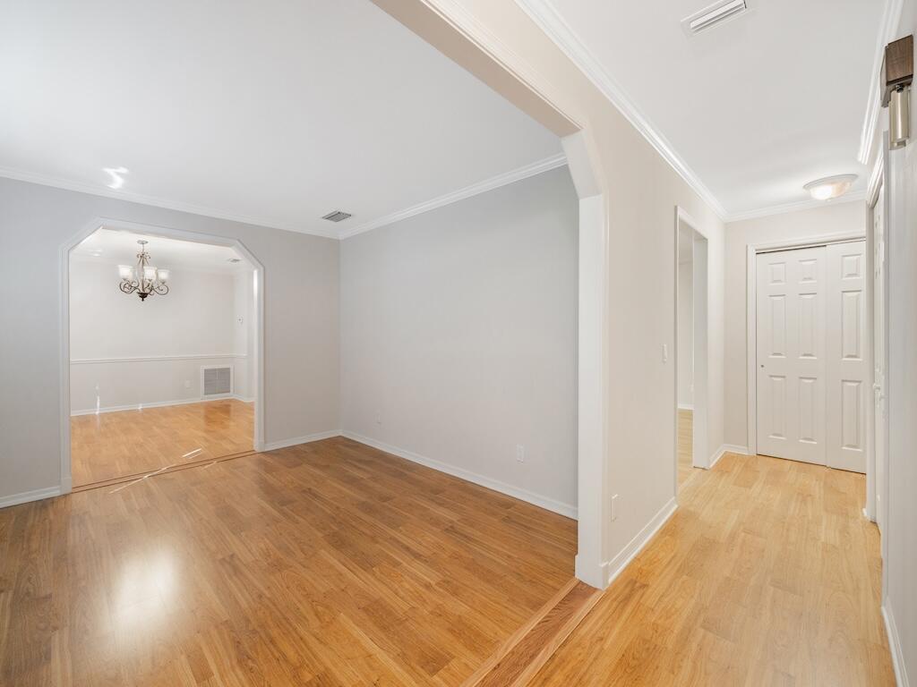 An interior view showing a living area with light wood floors and arched doorways — 4790 16th Street, Vero Beach FL 32966, VERO BEACH, FL