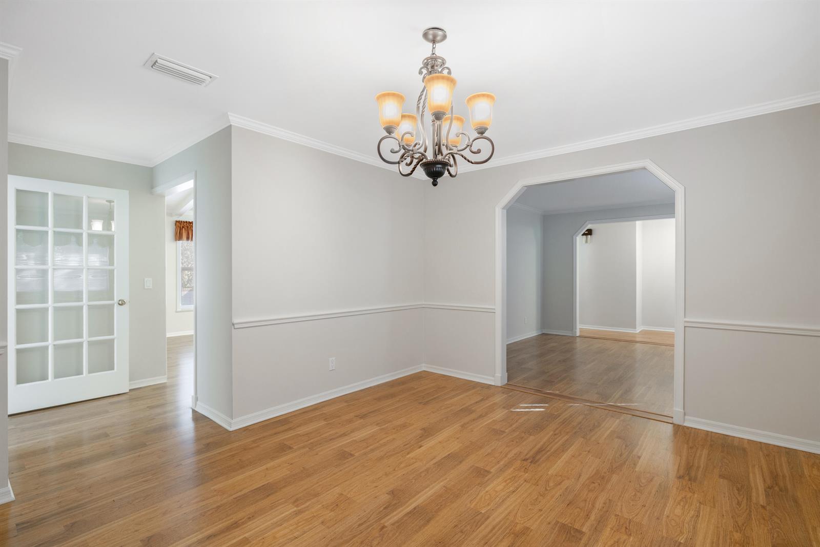 An empty dining room features light gray walls, white chair rail molding, and a chandelier — 4790 16th Street, Vero Beach FL 32966, VERO BEACH, FL