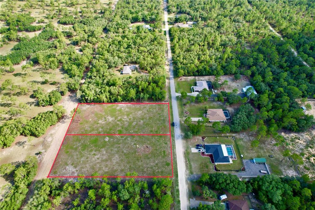 An aerial view shows two adjacent, cleared rectangular lots bordered by trees and a road — 0 SW 121 TERRACE SW, DUNNELLON, FL