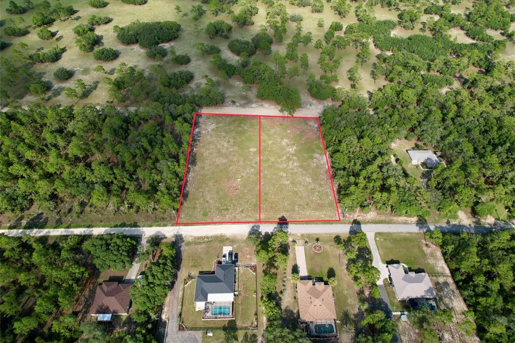 An aerial view shows two adjacent, cleared rectangular lots outlined in red along a road — 0 SW 121 TERRACE SW, DUNNELLON, FL