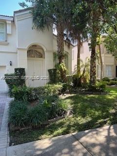 A two-story house exterior features a white stucco facade, arched entryway, and mature palm trees — 5003 SW 163rd Ave, Miramar FL 33027, MIRAMAR, FL