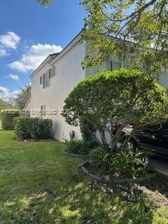 A two-story white stucco building is partially obscured by a large tree and landscaping — 5003 SW 163rd Ave, Miramar FL 33027, MIRAMAR, FL