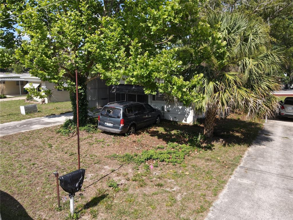 A dark minivan is parked on the lawn in front of a mobile home — 28814 HUBBARD STREET, LEESBURG, FL