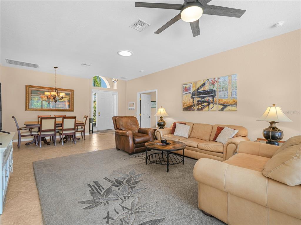 A living room and dining area feature tile floors, a ceiling fan, and beige furniture — 5337 HOGAN LANE, WINTER HAVEN, FL