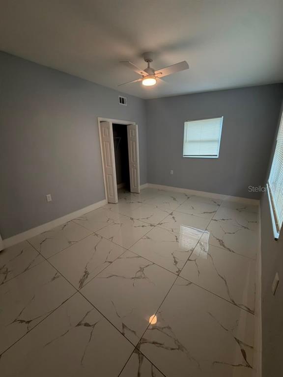 A bedroom with light gray walls, white marble-patterned tile flooring, and a ceiling fan — 2615 E 23RD AVENUE, TAMPA, FL
