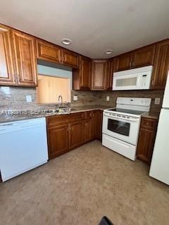 A kitchen features wood cabinets, granite countertops, and white appliances — 421 NE 14th Ave # 401, Hallandale Beach FL 33009, HALLANDALE BEACH, FL