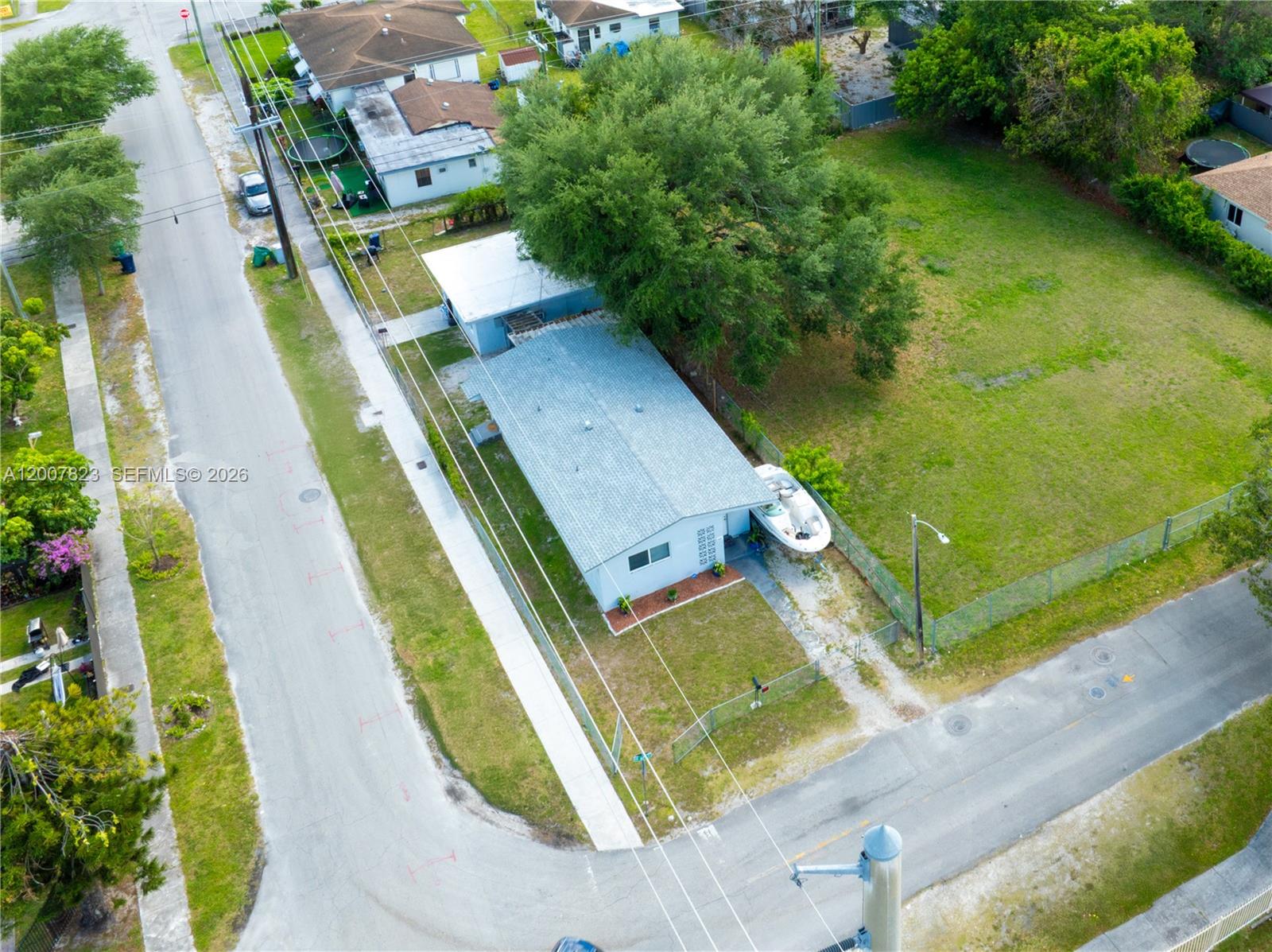An aerial view shows a single-story house with a boat parked on its side lawn — 2406 NW 67th St, Miami FL 33147, MIAMI, FL