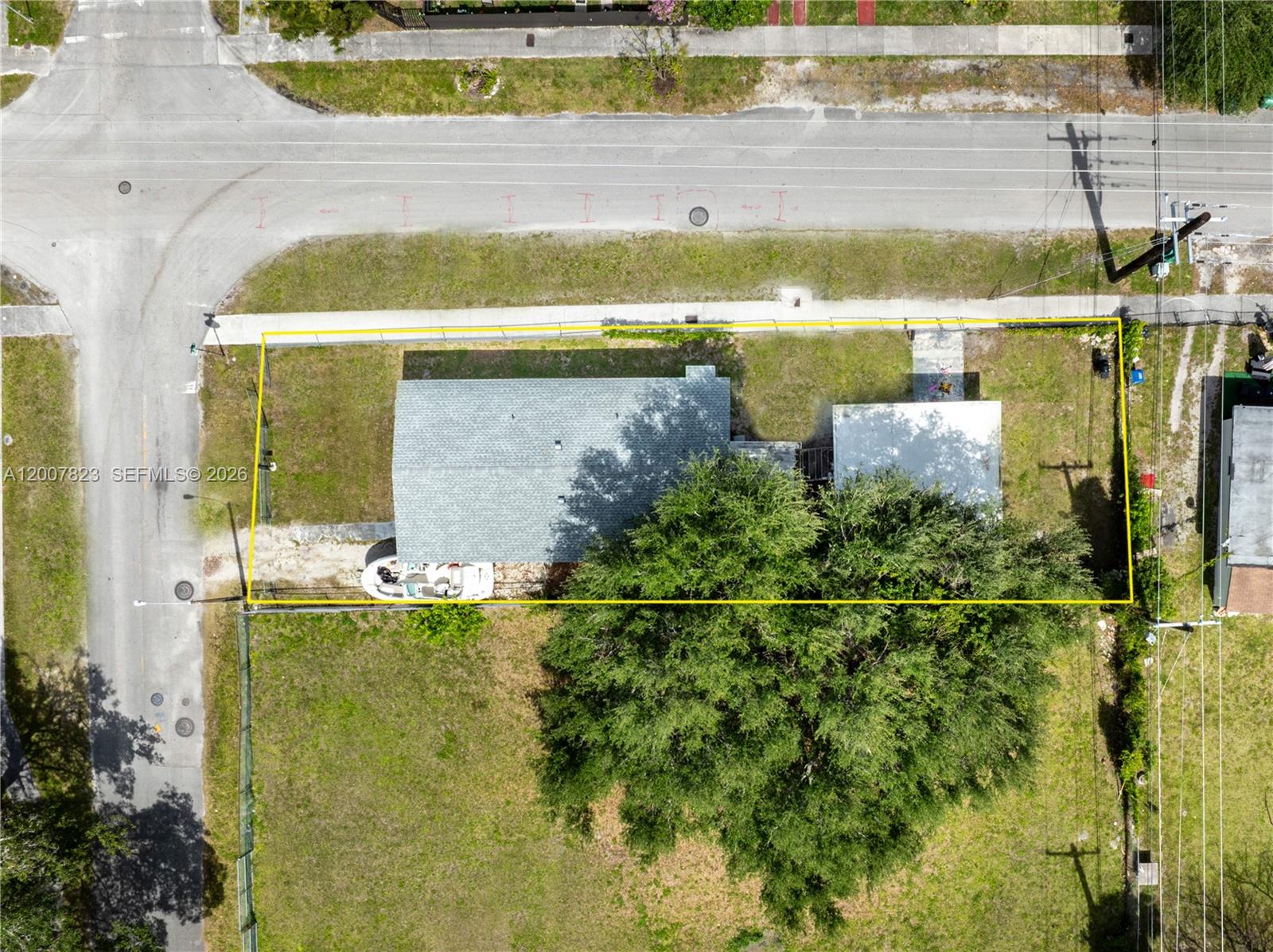 An aerial view shows a house with a large tree on a fenced lot — 2406 NW 67th St, Miami FL 33147, MIAMI, FL
