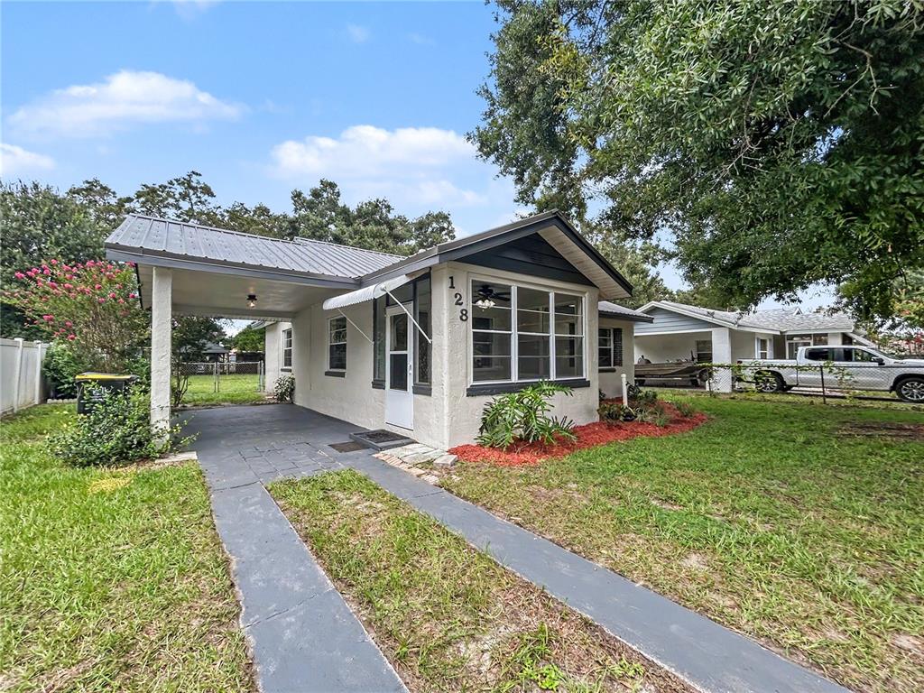 A single-story house with a carport, a metal roof, and a front yard — 128 CENTER STREET, WINTER HAVEN, FL