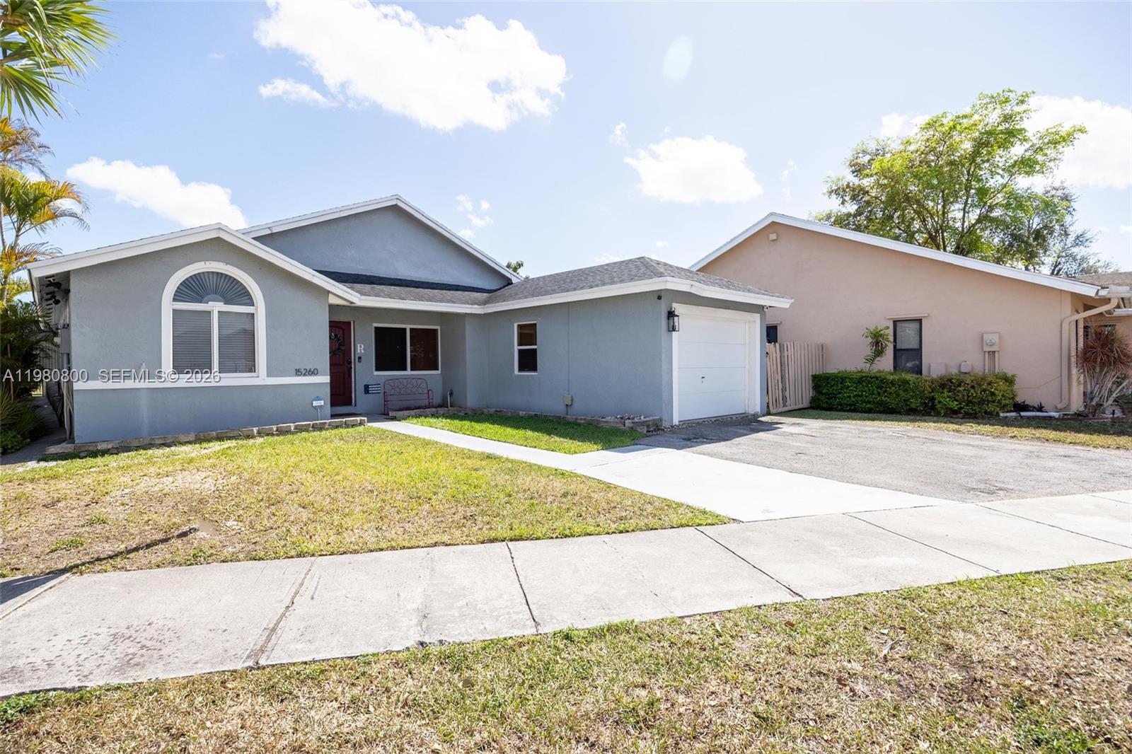 A single-story gray house with a white garage door and a front walkway — 15260 SW 57th St, Miami FL 33193, MIAMI, FL