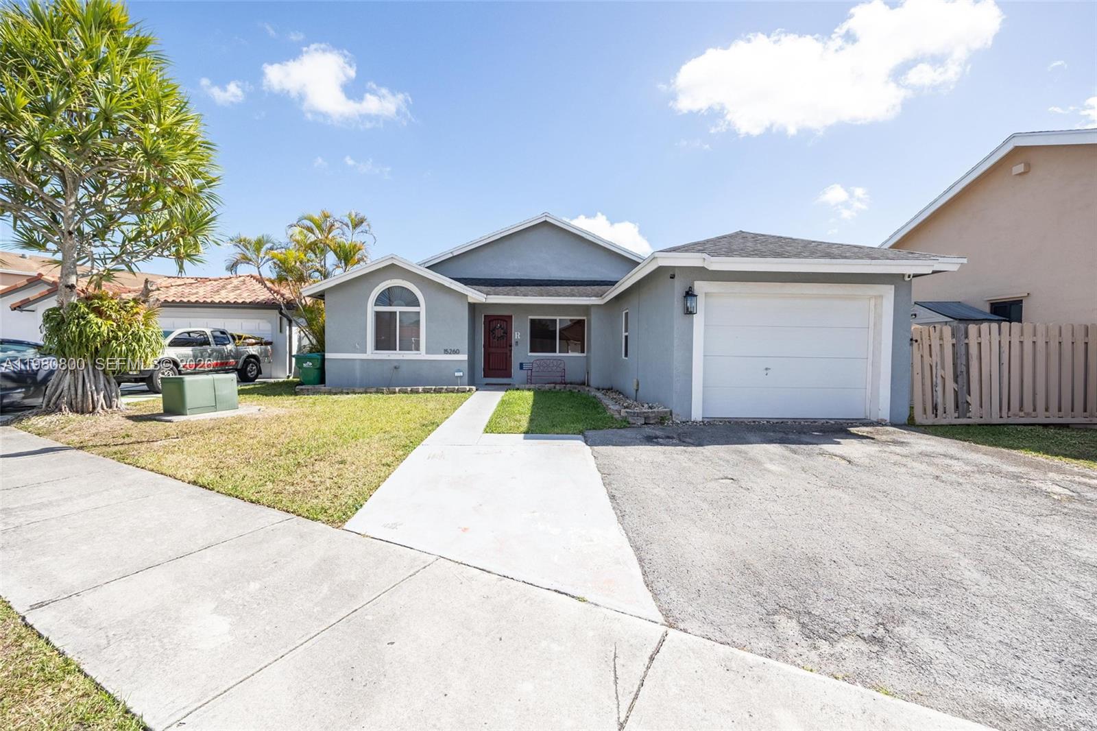 A single-story gray house features a white garage door and a concrete driveway — 15260 SW 57th St, Miami FL 33193, MIAMI, FL