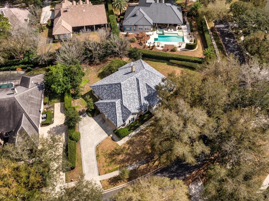 An aerial view shows a house with a gray tile roof and a concrete driveway — 25516 HAWKS RUN LANE, SORRENTO, FL
