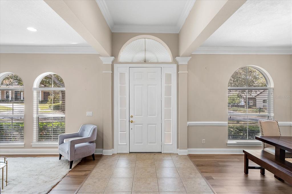 An entryway features a white front door with a transom window, tile flooring, and arched windows — 25516 HAWKS RUN LANE, SORRENTO, FL