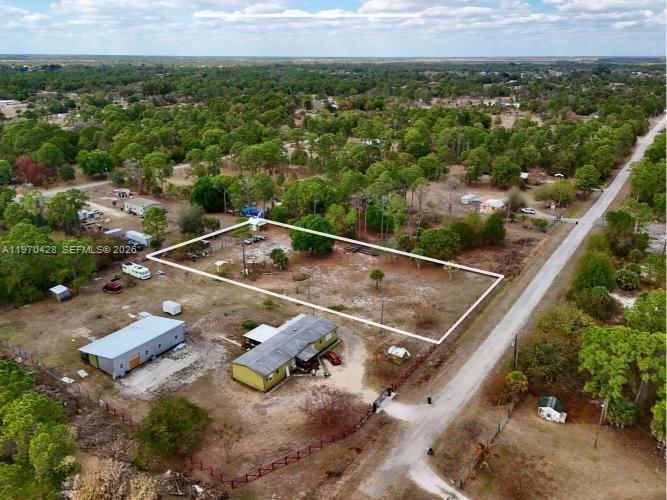 An aerial view shows a large, rectangular vacant lot outlined in white next to a house — 220 N PALOMINO ST, Clewiston FL 33440, CLEWISTON, FL