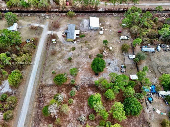 An aerial view shows a rural property with a house, outbuildings, and scattered trees — 220 N PALOMINO ST, Clewiston FL 33440, CLEWISTON, FL