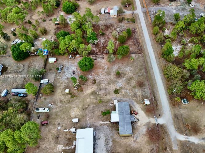 An aerial view shows a rural property with several structures, trees, and a dirt road — 220 N PALOMINO ST, Clewiston FL 33440, CLEWISTON, FL