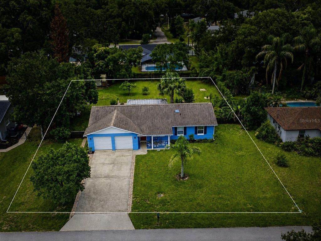 A blue brick house features a red front door and a decorative mosaic tile porch — 912 E ARIZONA AVENUE, DELAND, FL