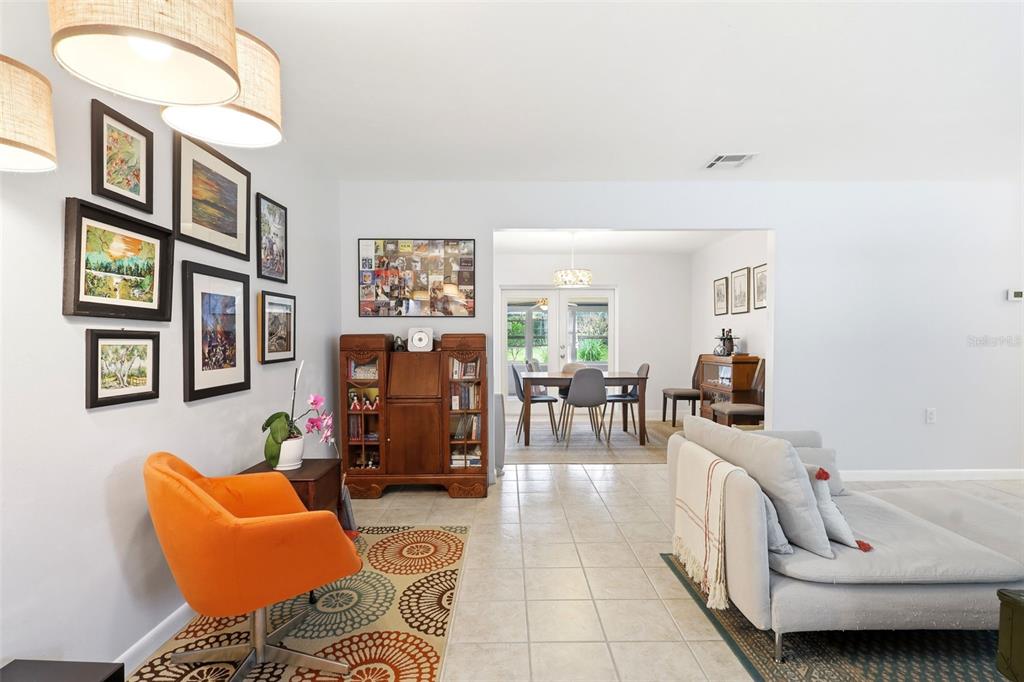 A living room features light tile floors, a sectional sofa, and a gallery wall — 912 E ARIZONA AVENUE, DELAND, FL