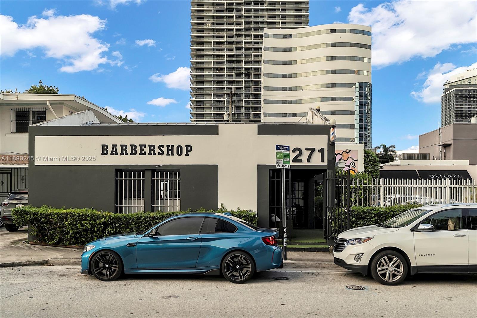 A blue coupe and a white SUV are parked in front of a barbershop building — 2700 Biscayne Blvd, Miami FL 33137, MIAMI, FL