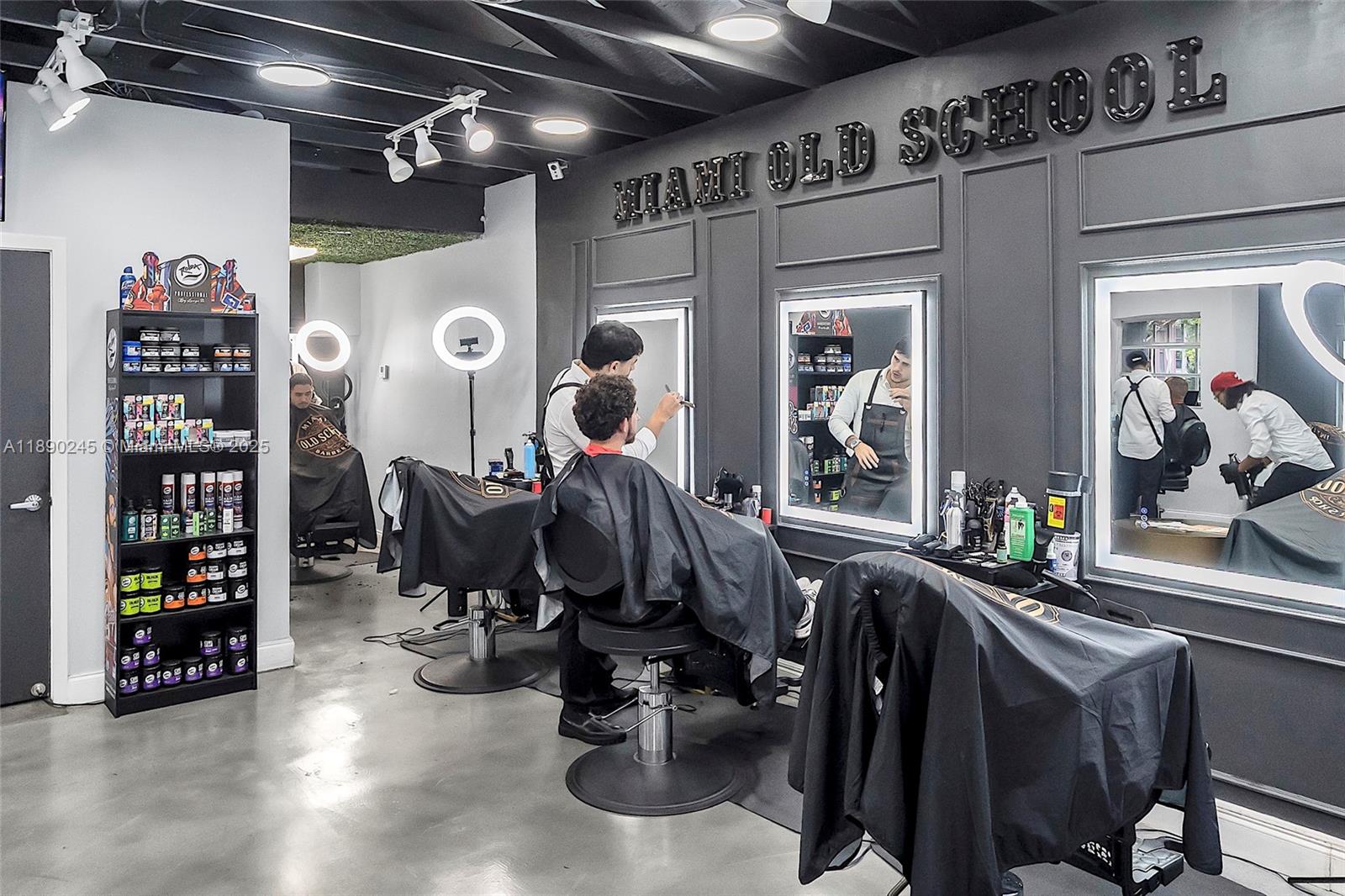 A barbershop interior features multiple styling stations with mirrors, black chairs, and product shelving — 2700 Biscayne Blvd, Miami FL 33137, MIAMI, FL