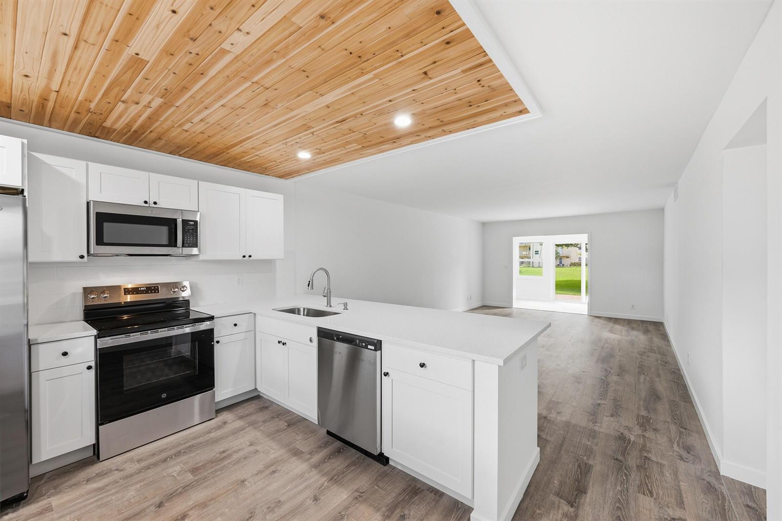 A kitchen with white cabinets, stainless steel appliances, and a wood-paneled ceiling — 330 NE 26th Avenue # 112, Boynton Beach FL 33435, BOYNTON BEACH, FL