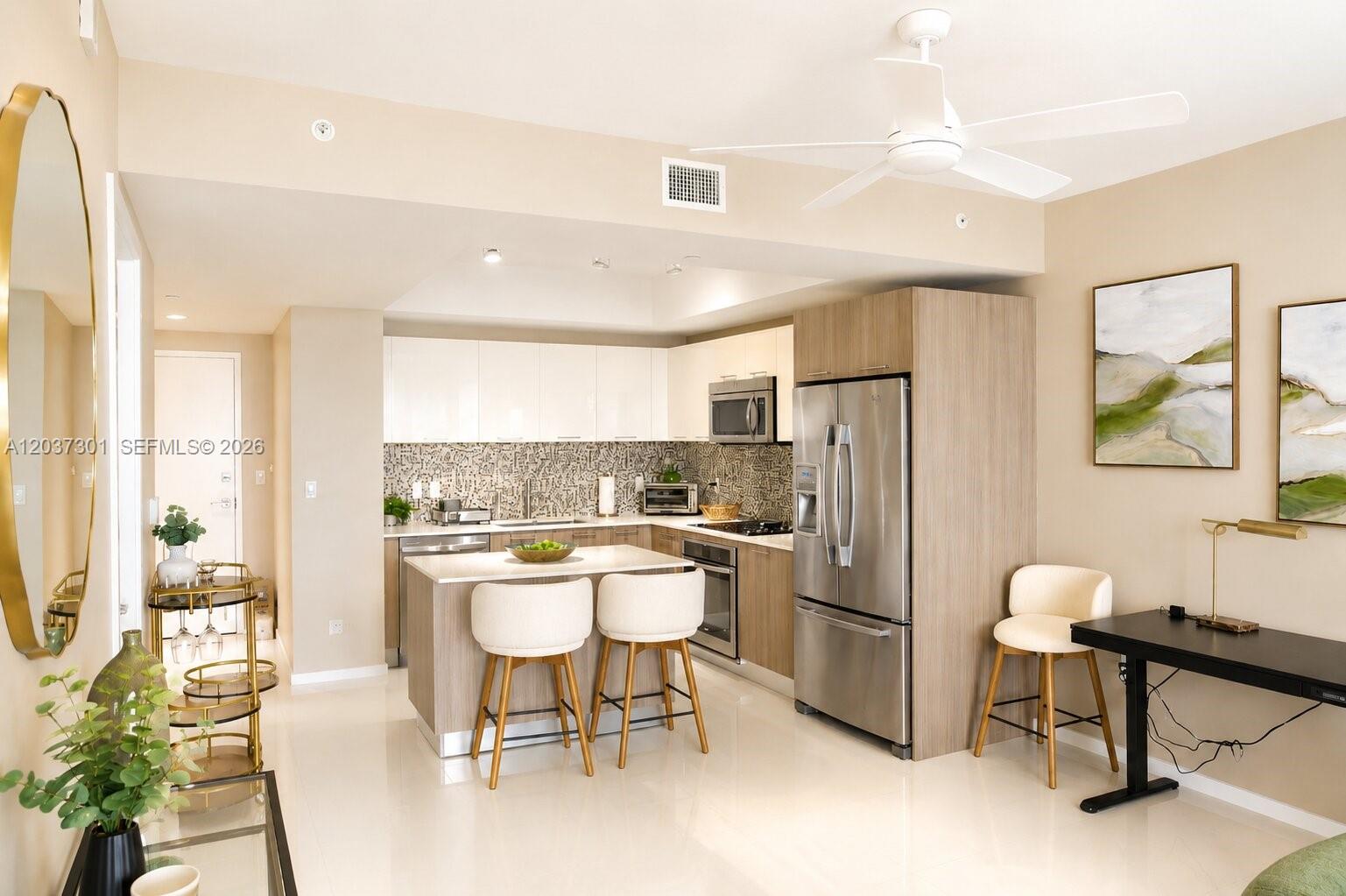 A modern kitchen features white upper cabinets, wood-tone lower cabinets, a breakfast island, and stainless appliances — 5300 Paseo Blvd # 1510, Doral FL 33166, DORAL, FL