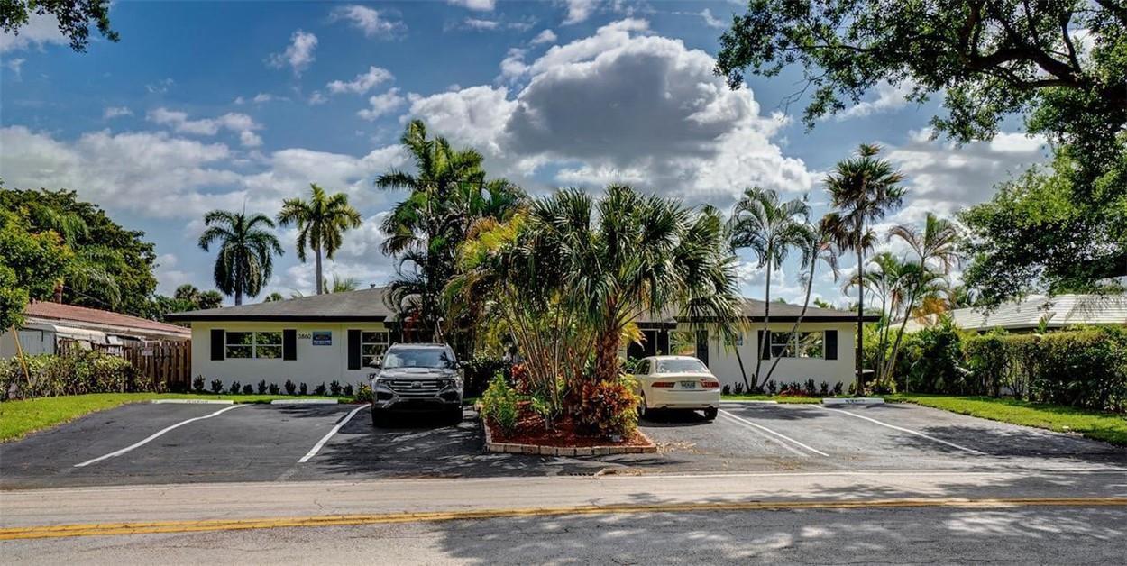 A single-story house with a white exterior, palm trees, and a paved parking lot — 3860 NE 23rd Avenue, Lighthouse Point FL 33064, LIGHTHOUSE POINT, FL