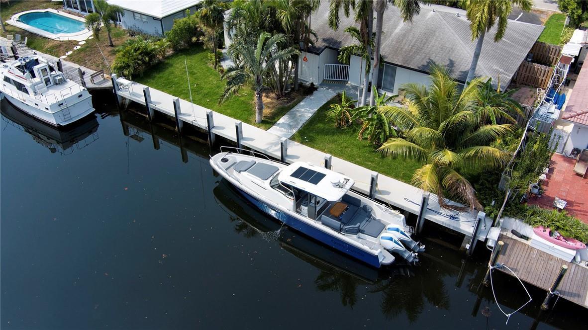 An aerial view shows a boat docked at a canal-front home with a swimming pool — 3860 NE 23rd Avenue, Lighthouse Point FL 33064, LIGHTHOUSE POINT, FL