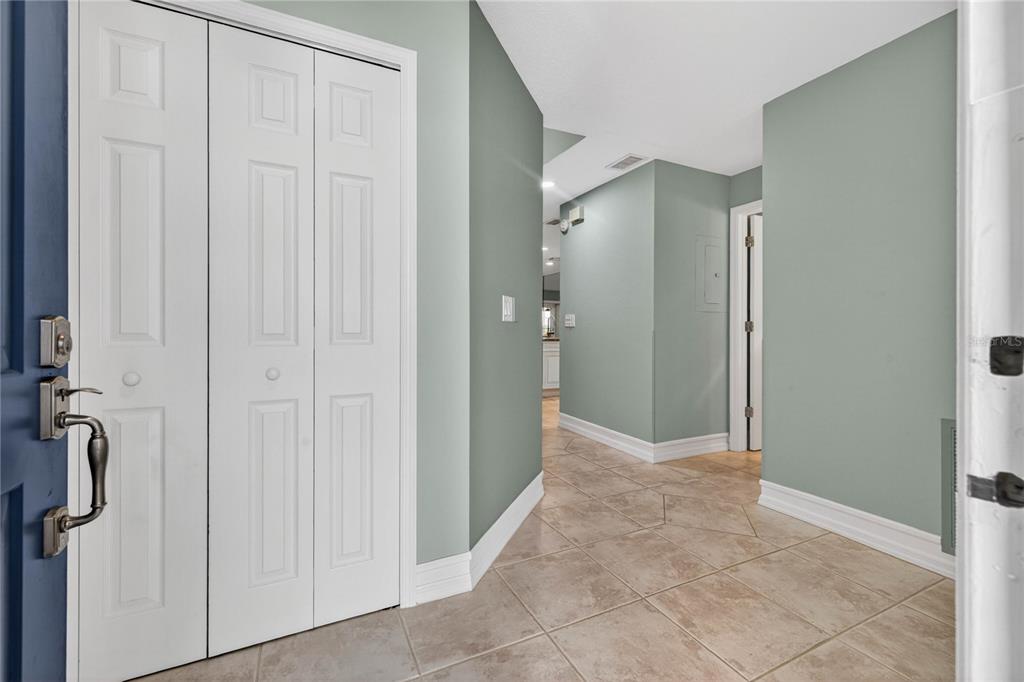 An entryway features light green walls, a white bi-fold closet, and beige tile flooring — 9050 PARK BOULEVARD UNIT 7, SEMINOLE, FL