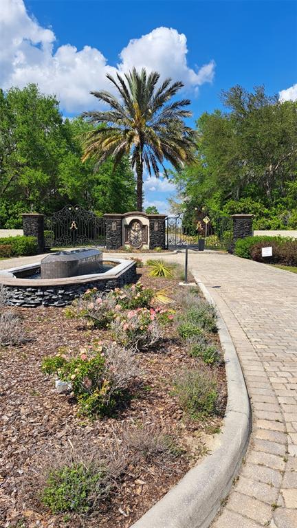 A stone-paved driveway leads to a gated entrance with a fountain and a palm tree — 00 SE 101ST CT ROAD, BELLEVIEW, FL