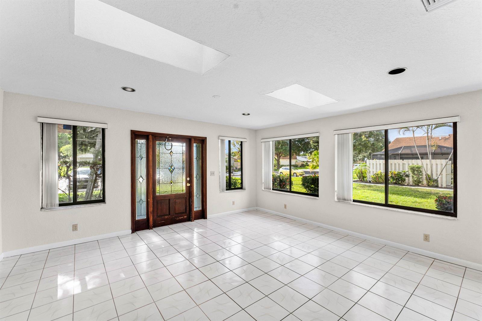A bright, tiled entryway features a stained-glass front door, multiple windows, and two skylights — 900 NW 30th Avenue # D, Delray Beach FL 33445, DELRAY BEACH, FL