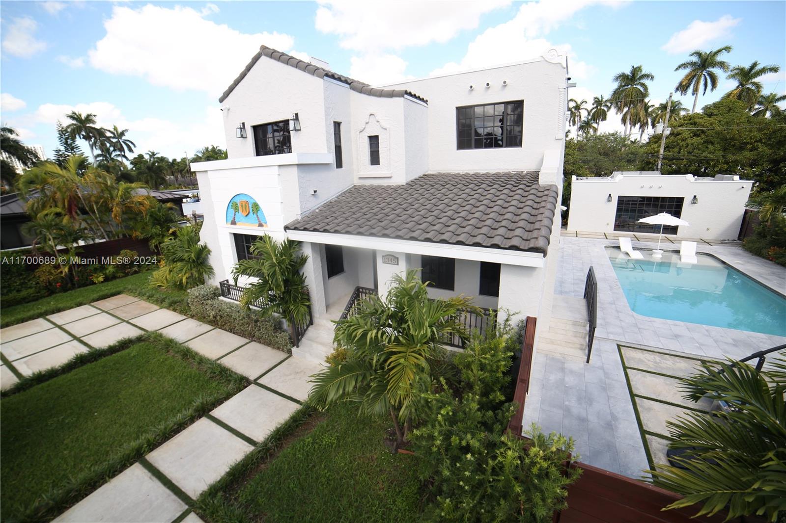 An exterior view of a two-story white house with a tiled roof and swimming pool — 1345 Hollywood Blvd, Hollywood FL 33019, HOLLYWOOD, FL