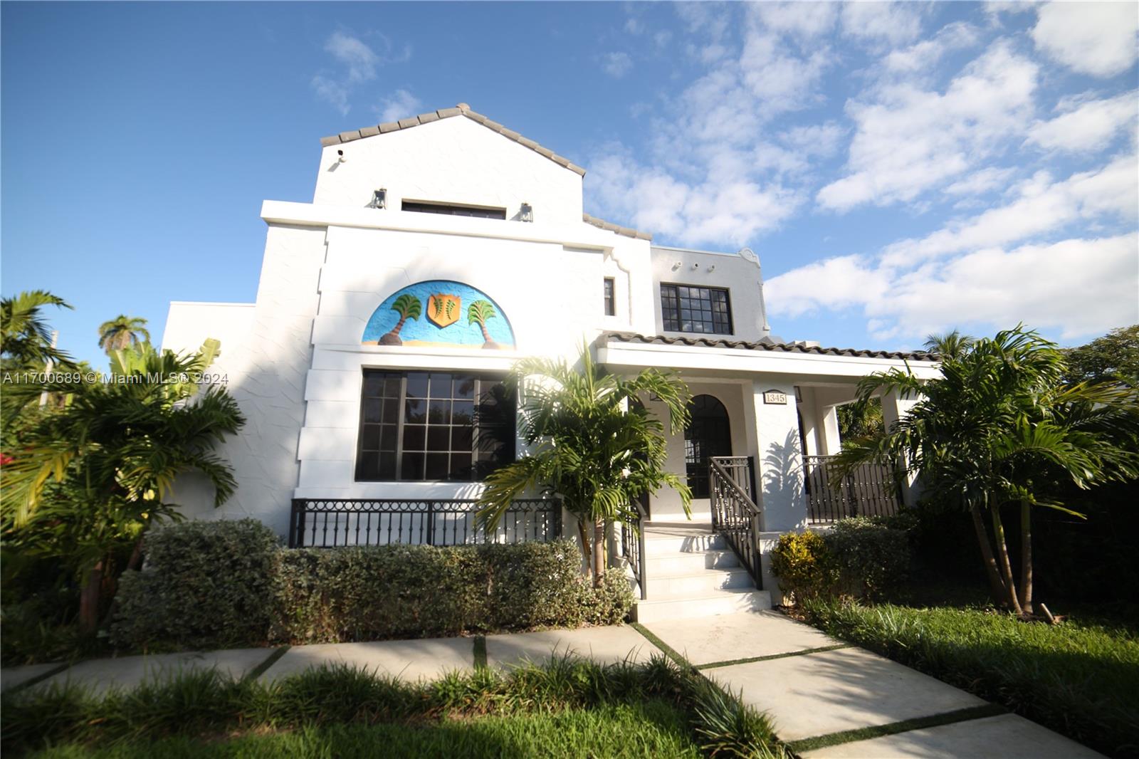 A white two-story house features a decorative arched mural, palm trees, and a front porch — 1345 Hollywood Blvd, Hollywood FL 33019, HOLLYWOOD, FL