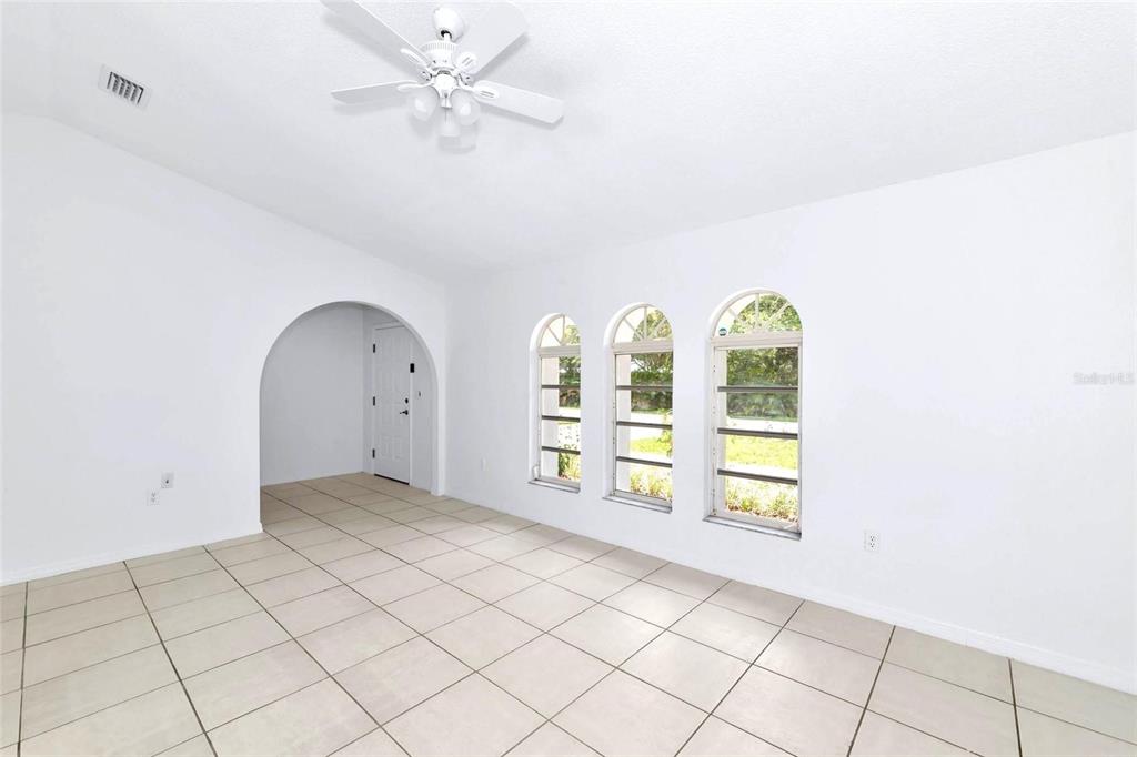 A bright room with white walls, tiled floors, an arched entryway, and three arched windows — 4819 WECOMA AVENUE, NORTH PORT, FL