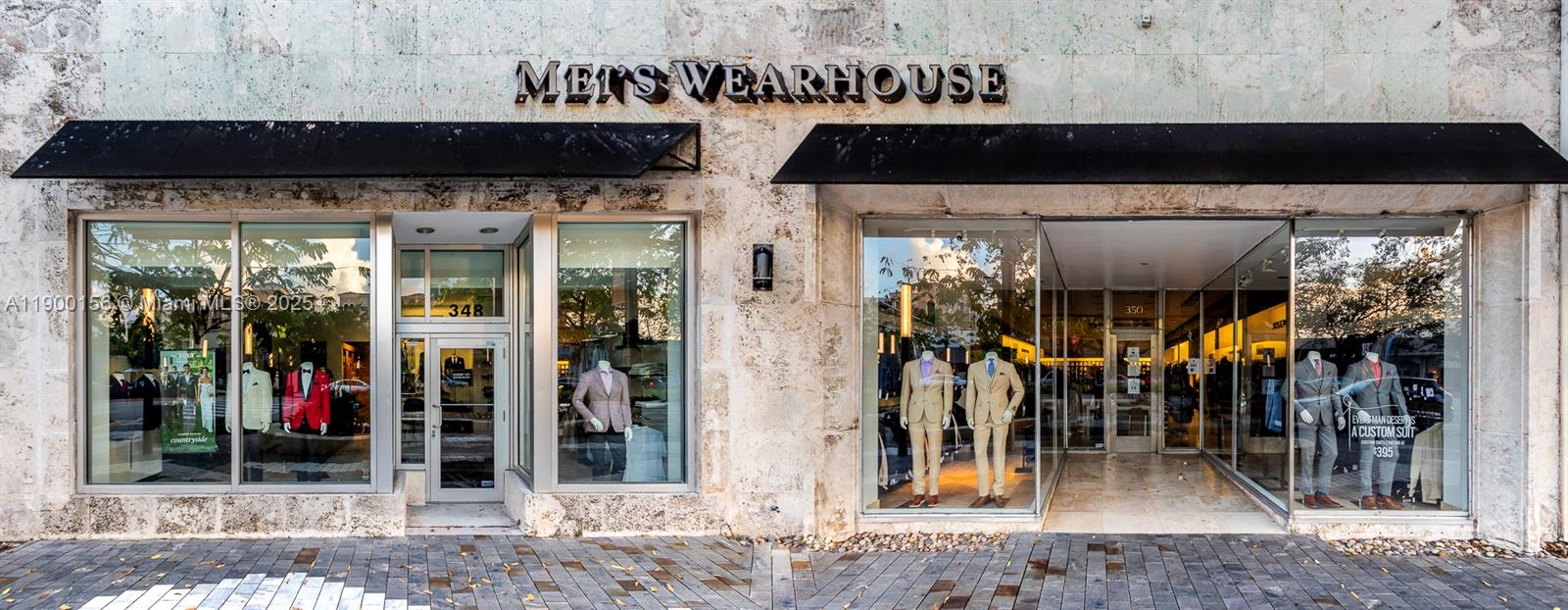 The exterior of a Men's Wearhouse storefront features stone walls, black awnings, and glass windows — 350 Miracle Mile, Coral Gables FL 33134, CORAL GABLES, FL