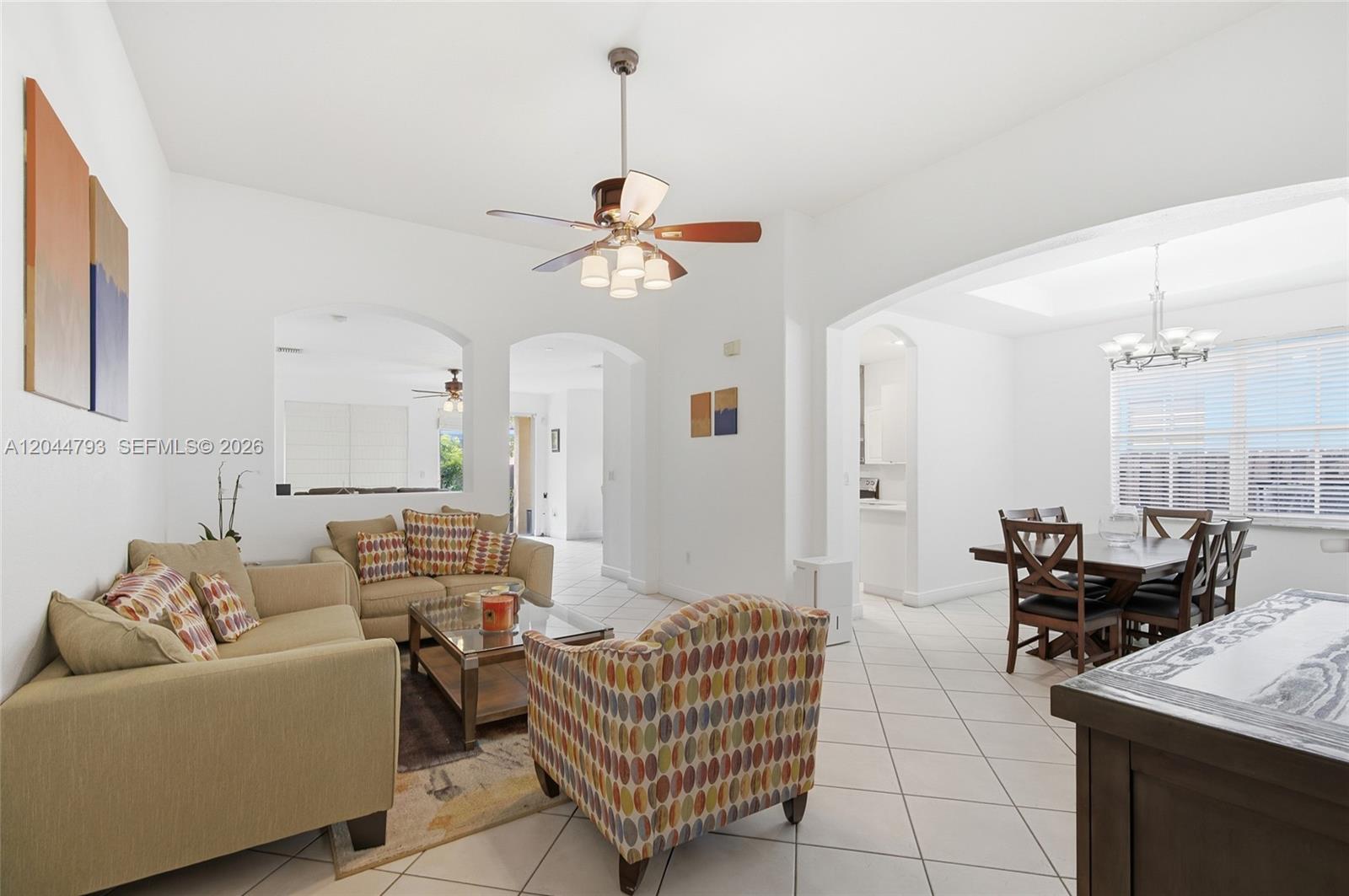 A living room and dining area feature white walls, tile floors, and a ceiling fan — 15125 SW 12th Ter, Miami FL 33194, MIAMI, FL