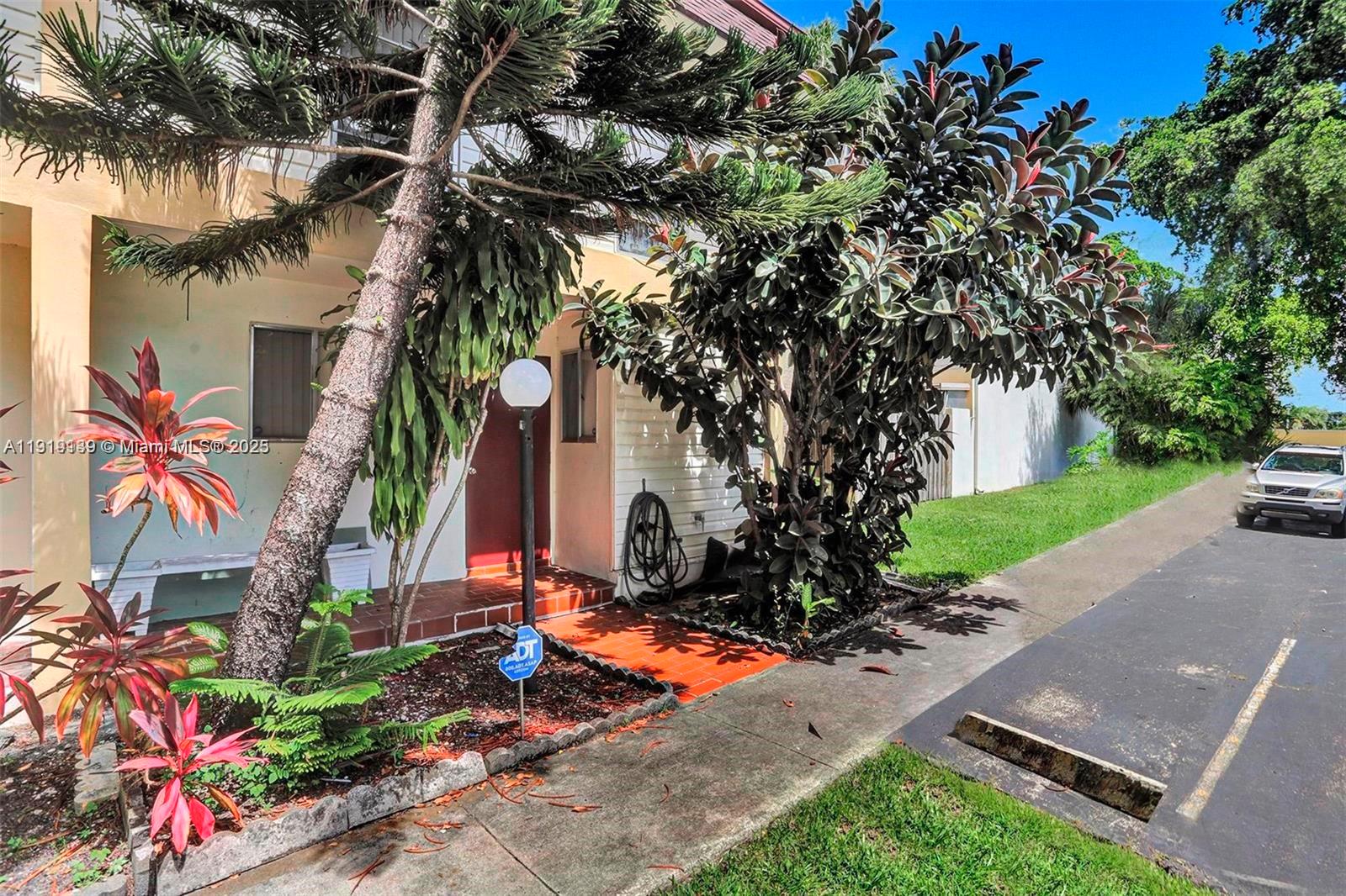 A residential building exterior features a red front door, landscaping, and a paved driveway — 2701 N 34th Ave # 1D, Hollywood FL 33021, HOLLYWOOD, FL