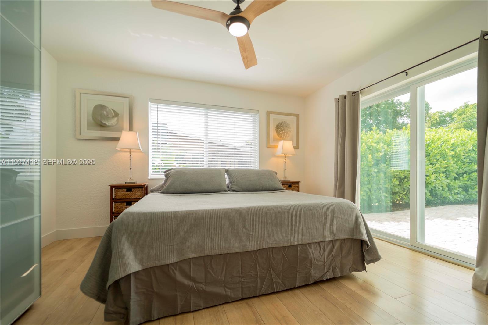 A bedroom features a bed, two nightstands, a ceiling fan, and sliding glass doors — 269 SE 8th Ave, Deerfield Beach FL 33441, DEERFIELD BEACH, FL