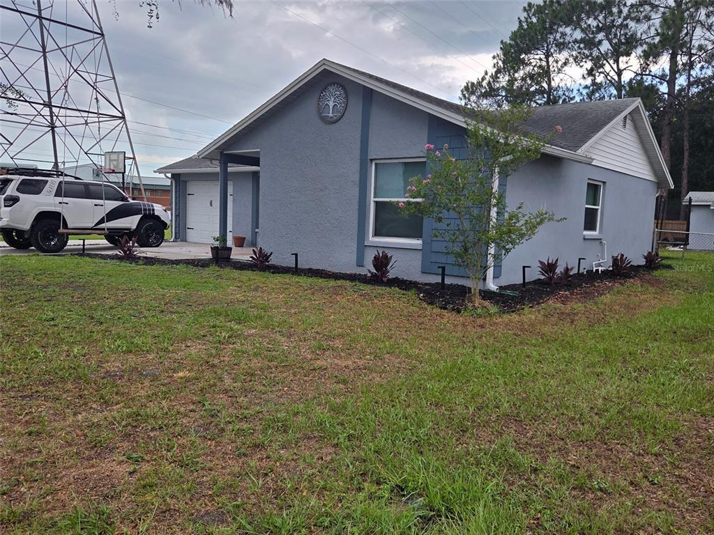 A single-story gray house with a white garage door and a tree emblem on the gable — 3101 SEVEN SPRINGS BOULEVARD, NEW PORT RICHEY, FL