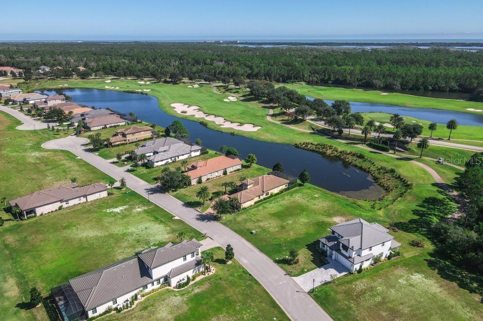 An aerial view shows houses along a road bordering a golf course and a lake — 339 HIBISCUS WAY, PALM COAST, FL