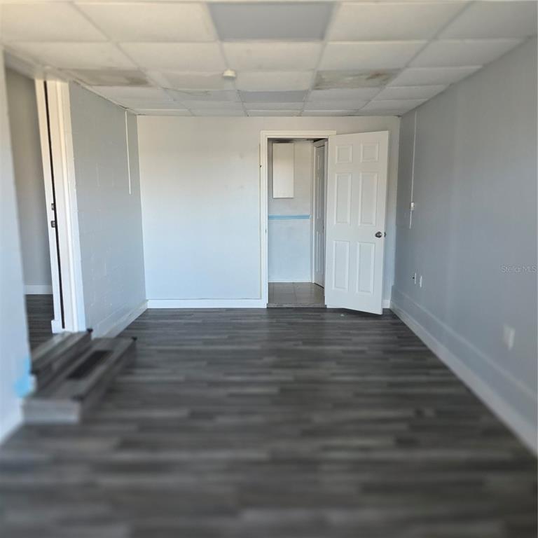 An interior view of a room with gray walls, wood-look flooring, and a drop ceiling — 60 S SEMORAN BOULEVARD, ORLANDO, FL