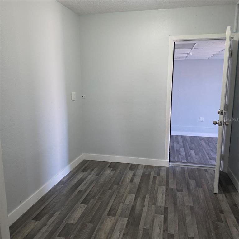 A small room with light blue walls, white trim, and gray wood-look flooring — 60 S SEMORAN BOULEVARD, ORLANDO, FL
