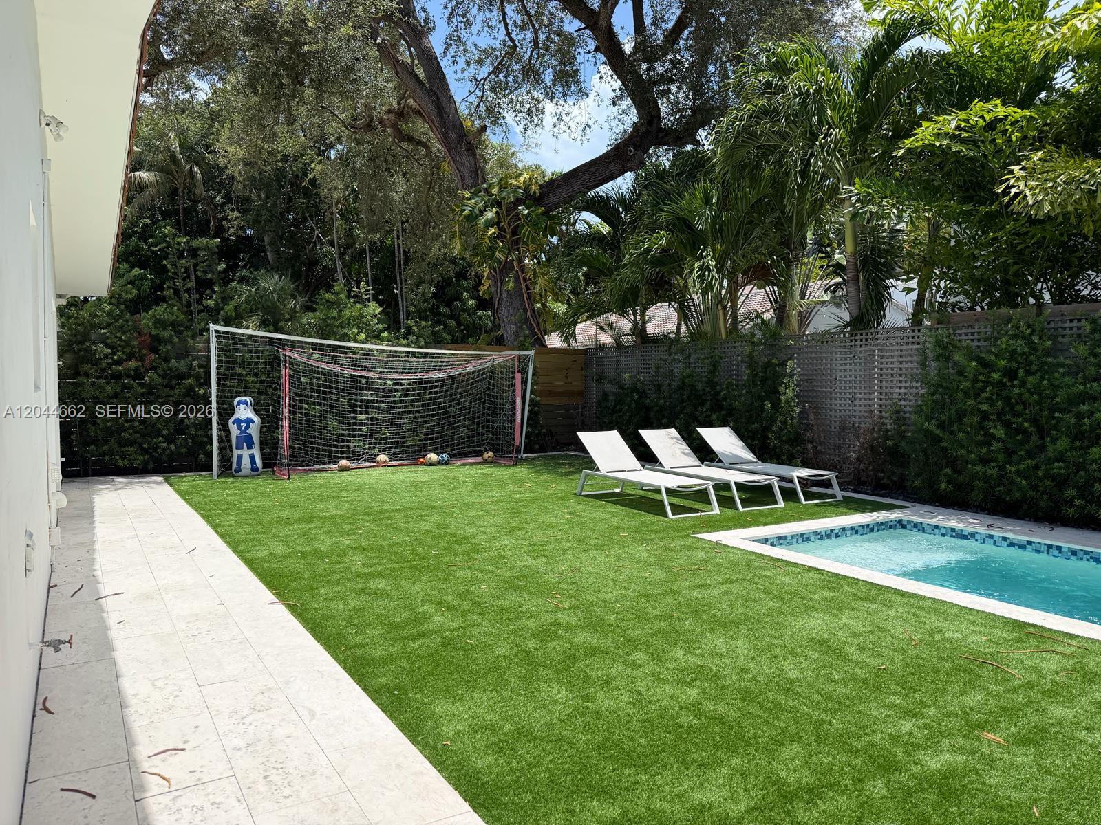 A backyard features a soccer goal, three lounge chairs, and a small swimming pool — 2401 SW 16th Ct, Miami FL 33145, MIAMI, FL
