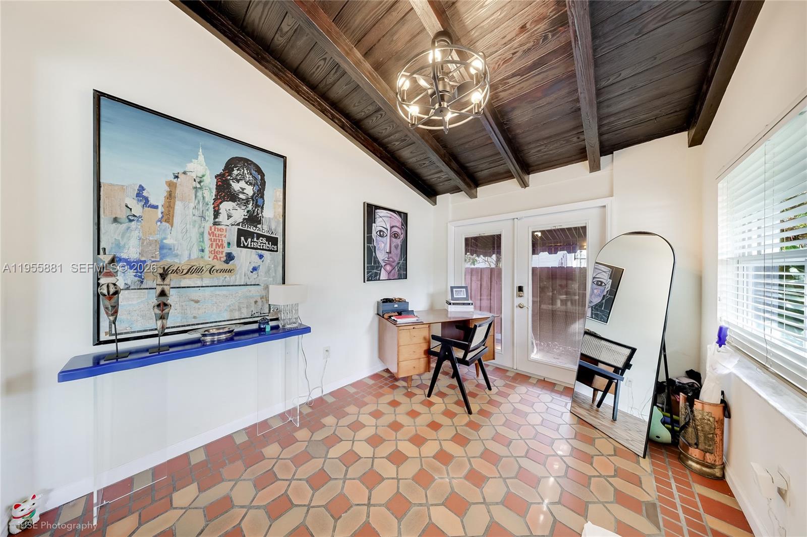 A home office features a wood-beamed ceiling, tiled floor, desk, and large wall art — 717 NE 73rd St, Miami FL 33138, MIAMI, FL