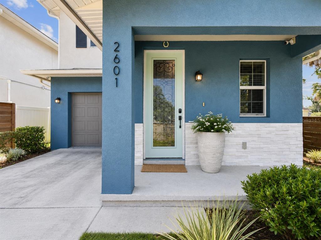 A blue house exterior features a light green front door, stone siding, and a driveway — 2601 E LAKE AVENUE UNIT A, TAMPA, FL