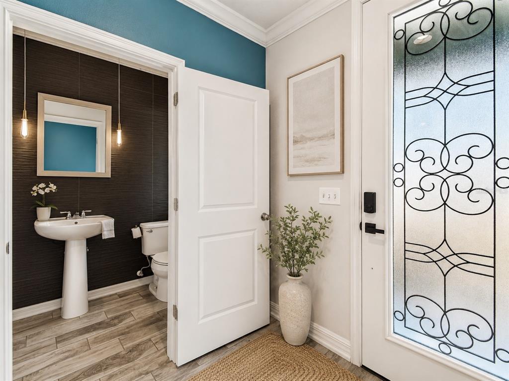 A view of a powder room with dark textured walls next to a front entryway — 2601 E LAKE AVENUE UNIT A, TAMPA, FL