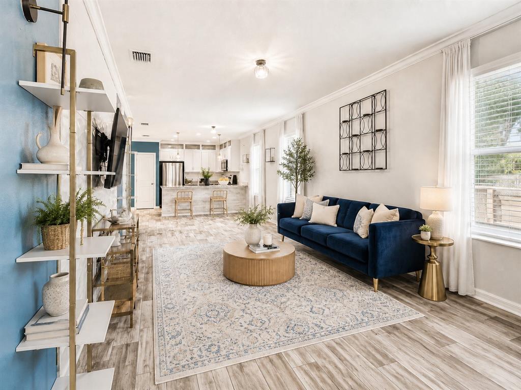 A living room with a blue sofa, round wooden coffee table, and open-concept kitchen — 2601 E LAKE AVENUE UNIT A, TAMPA, FL