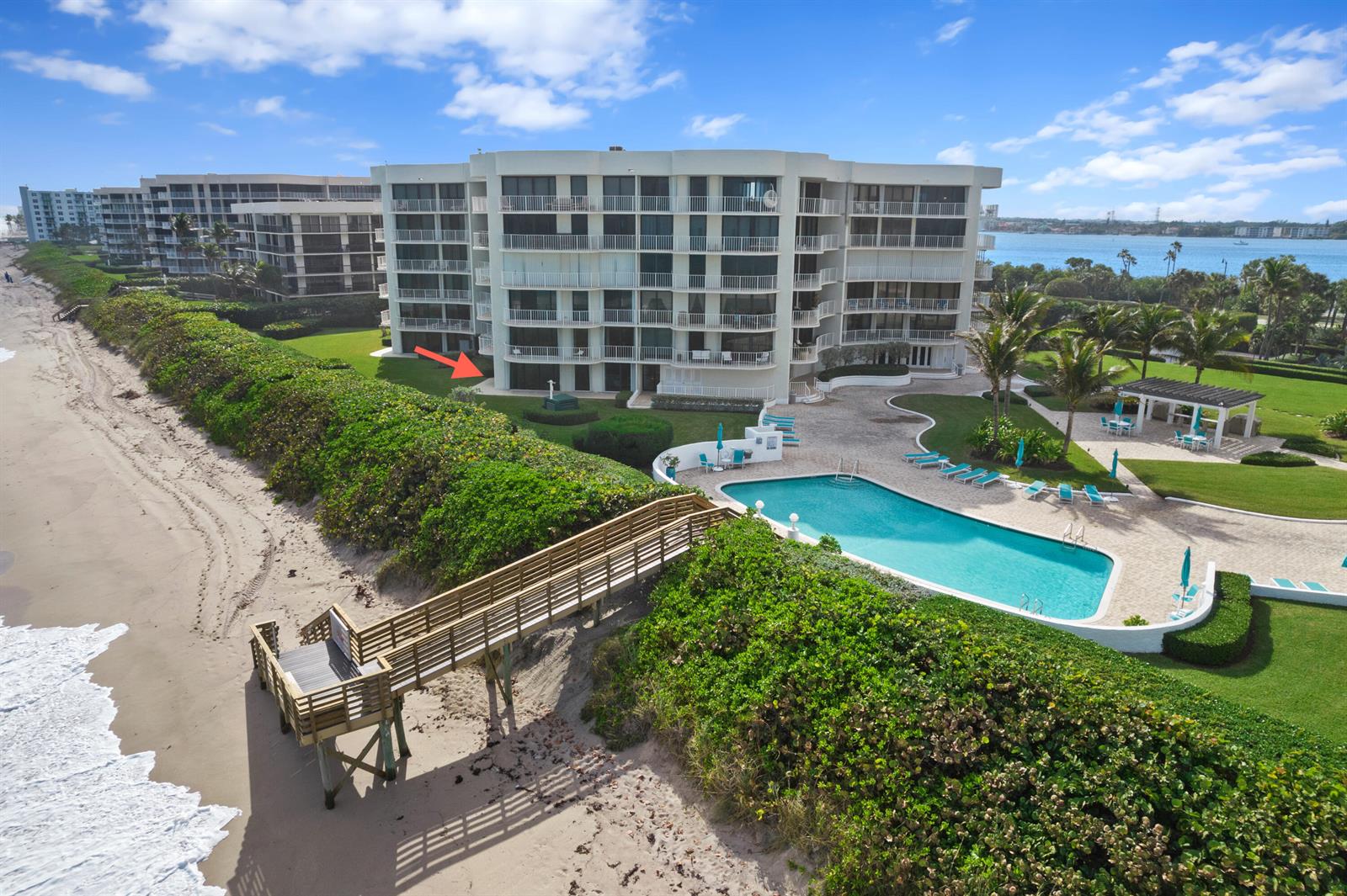 An aerial view shows a beachfront condominium building with a pool, deck, and wooden walkway — 3360 S Ocean Boulevard, Palm Beach FL 33480, PALM BEACH, FL