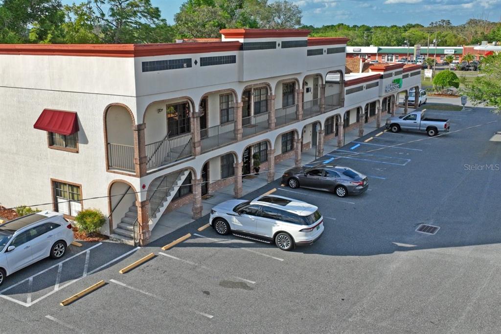 An aerial view of a two-story commercial building with arched walkways and a parking lot — 5330 SPRING HILL DRIVE UNIT A, SPRING HILL, FL