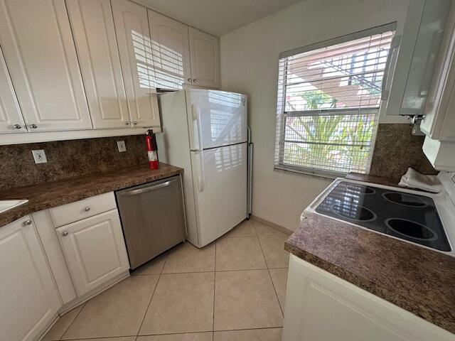 A kitchen features white cabinets, a stainless steel dishwasher, a white refrigerator, and brown countertops — 21 Abbey Lane # 107, Delray Beach FL 33446, DELRAY BEACH, FL